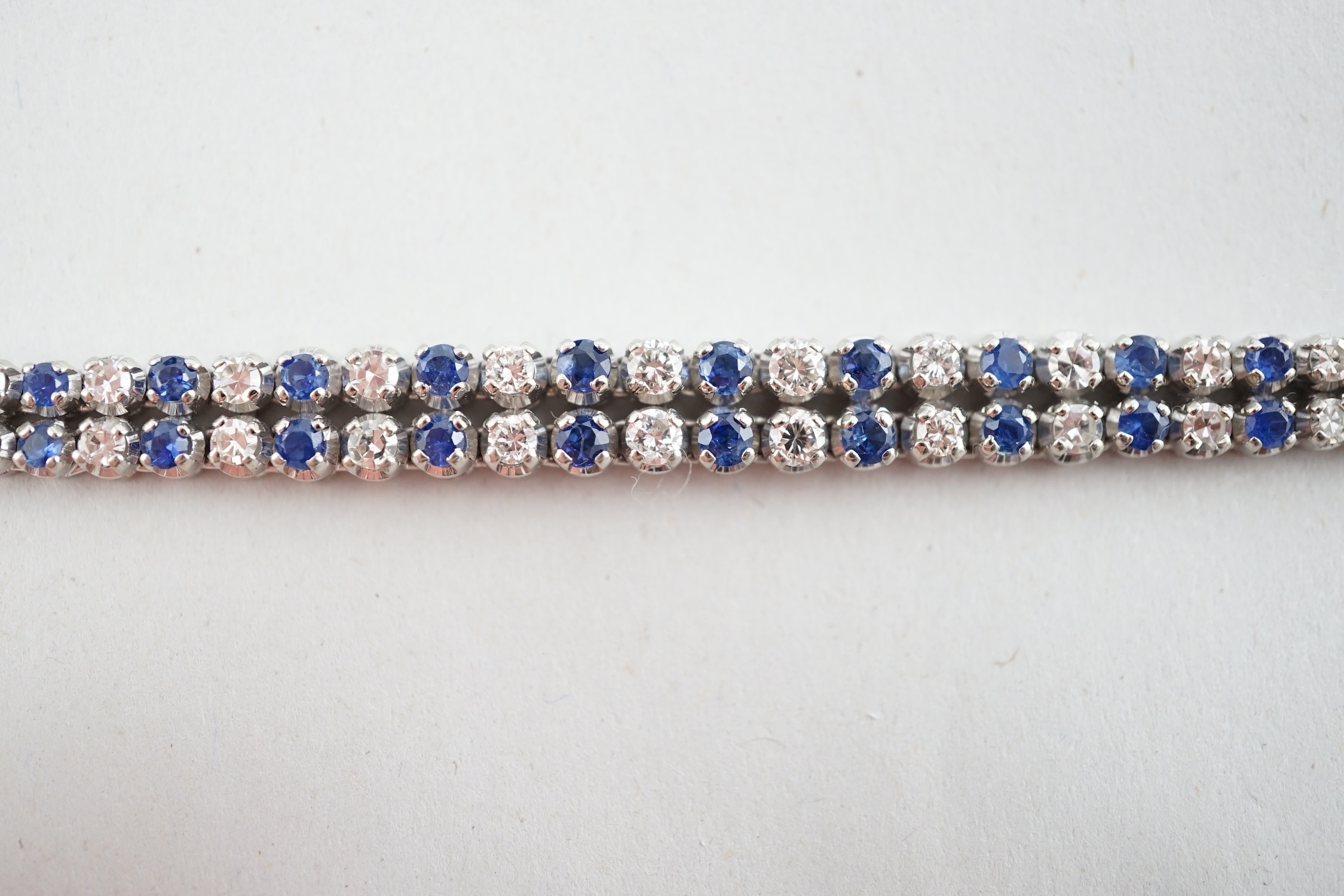 A 1960's 14ct white gold, sapphire and diamond two row line bracelet